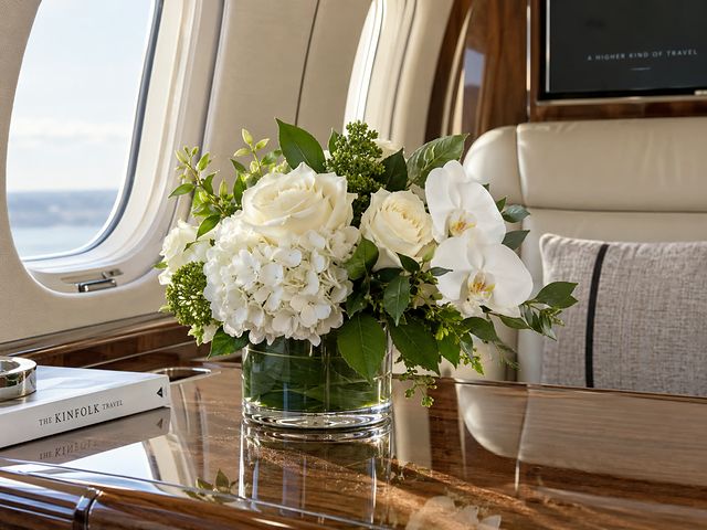 Compact white floral arrangement in a low glass vessel